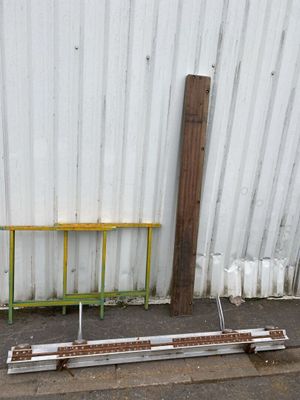 a yellow bench sitting next to a metal fence