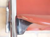 a close up of a red chair with a leather seat