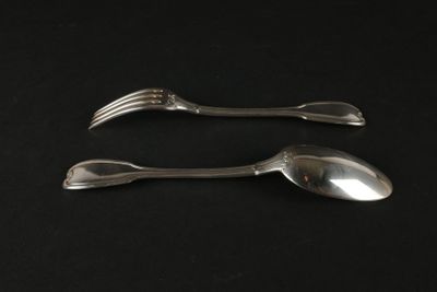 deux cuillères et une fourchette posées sur une surface noire