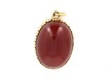 a close up of a red stone pendant on a white background
