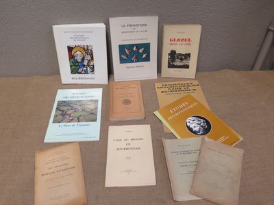 several books are sitting on a table in front of a wall