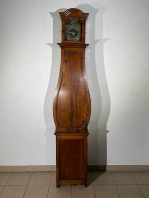 a tall wooden grandfather clock in the corner of a room