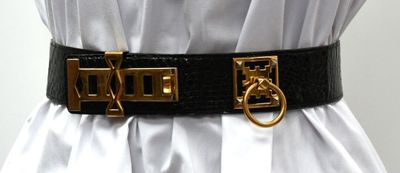 a woman wearing a belt with a gold buckle on it