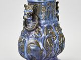 a blue vase with a lion head on it