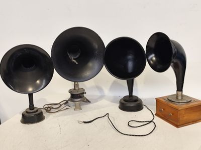 trois enceintes noires posées sur une table, à côté d'une caisse en bois