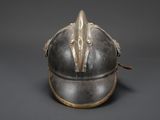 an old helmet with a metal handle on a gray background