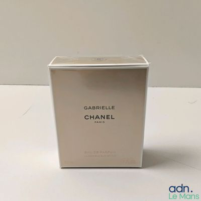 un flacon de parfum Chanel dans un coffret blanc posé sur une table
