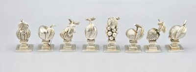 un ensemble de figurines en argent représentant des oiseaux et des fleurs, posées sur des socles