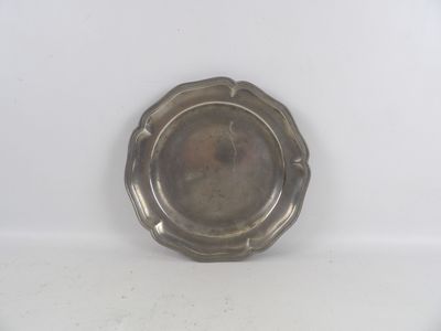 une assiette ancienne en argent, ornée d'un motif floral sur le bord