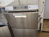 a silver dishwasher sitting in a kitchen next to a trash can