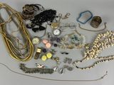 many different types of necklaces and bracelets laid out on a table