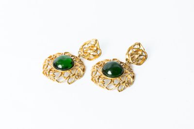 une paire de boucles d'oreilles vertes et dorées sur fond blanc