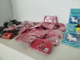 many bags of pink and white items sitting on a table