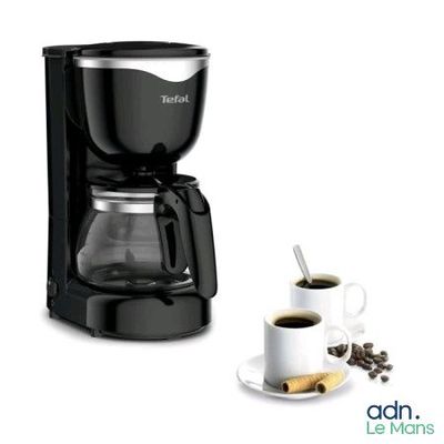 the coffee maker is next to a cup of coffee on a plate