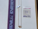 a purple ribbon and a necklace on a table