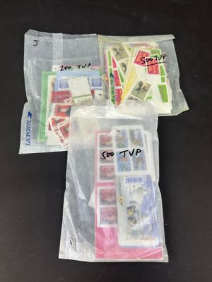 un sachet de timbres posé sur une table à côté d'un téléphone portable