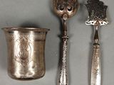 two spoons and a cup sitting on a table