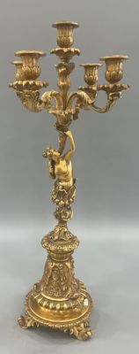 an antique brass candelab with four candles and a bird on top