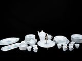 beaucoup d'assiettes et de tasses blanches et bleues sur la table