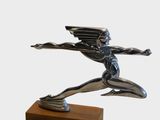 statue of a man with wings on a wooden base
