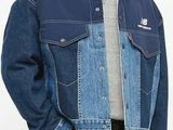 the man is wearing a denim jacket and black pants
