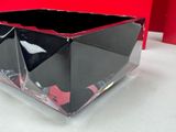 a black and red glass bowl on a white table