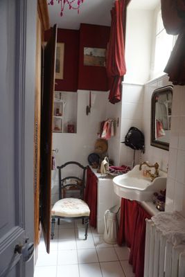 une salle de bains équipée d'un lavabo, de toilettes et d'une chaise