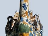 a vase that has a duck on it ' s head