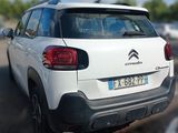 the rear end of a white car parked in a parking lot
