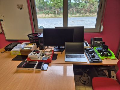 un bureau sur lequel se trouvent un ordinateur portable, un écran, un clavier et d'autres objets