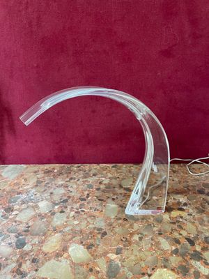 a clear glass sculpture on a table with a red background