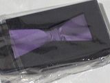 a purple bow tie in a black box on a white table