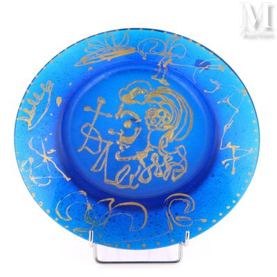 une assiette bleue sur laquelle est représentée une femme