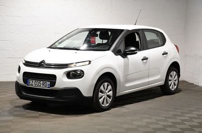 la citrole blanche est garee dans un garage au sol en damier