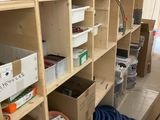 une pièce où s'entassent de nombreux cartons et des fournitures sur les étagères
