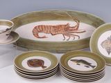 many plates and cups on the table with a picture of a lobster on them