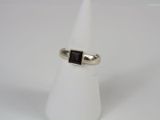 a silver ring with a black stone in the middle