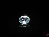un gros plan d'un diamant topaze bleue sur une surface noire