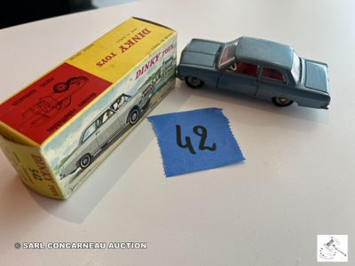 une petite voiture miniature posée sur une table à côté d'une boîte