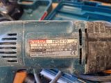 une perceuse posée au sommet d'une pile d'outils