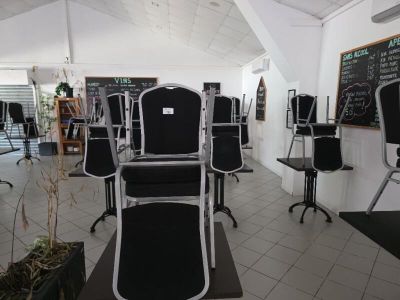 des tables et des chaises dans une pièce où se trouve un tableau noir accroché au mur