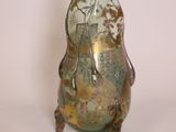 a glass vase with a bird on it sitting on a stand