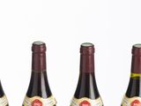six bottles of wine are lined up in a row on a table