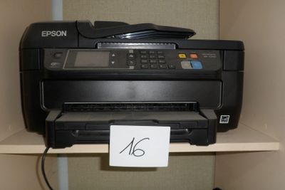une photo d'une imprimante posée sur une étagère, avec une étiquette de prix accrochée dessus