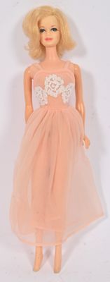 poupée Barbie vêtue d'une robe rose avec un corsage en dentelle blanche