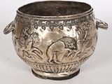 un vase en argent orné d'un cheval sur fond blanc