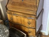 une petite table sur laquelle est posée une lampe, à côté d'une commode