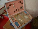 a pink suitcase with a bunch of jewelry inside of it