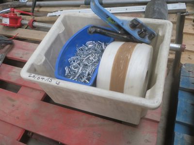 un seau d'outils posé sur une palette, à côté d'une paire de ciseaux