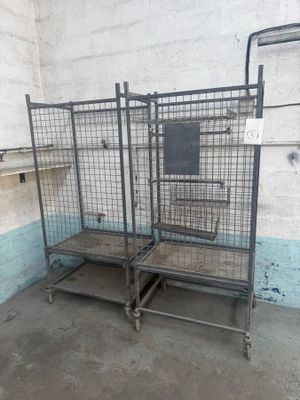 une cage métallique sur laquelle est posée une télévision, dans une pièce